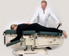 Chiropractor performing a back adjustment using the Flexion Distraction technique